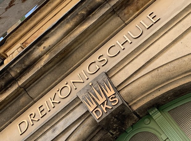 Schrift "Dreikönigschule" in gold am Portal und Logo DKS mit drei Kronen